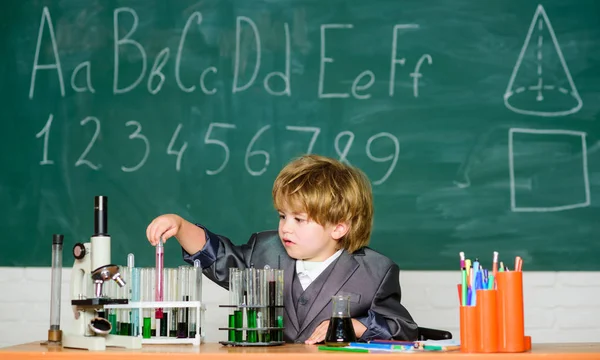 Boy near microscope and test tubes in school classroom. Kid study biology chemistry. Knowledge day. Basic knowledge primary school education. Happy childhood. Child enjoy studying. Knowledge concept — Stock Photo, Image