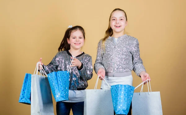 Gelukkige kinderen. Kleine meisje zusters online winkelen. Verkoop en kortingen. Sisterhood en familie. besparingen op aankopen. Kid mode. Shop Assistant met pakket. Kleine meisjes met boodschappentassen — Stockfoto