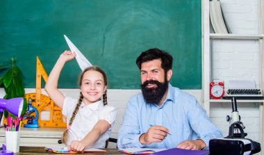 İşe odaklanmak. Okula geri dön. Özel öğretmenlik. sınıfta sakallı öğretmen adam ile küçük kız çocuk. bilgi günü. Evde eğitim. özel ders. baba ile kızı çalışma. Öğretmenler günü