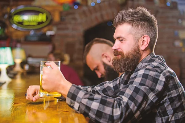 Homem com barba passar o lazer no bar escuro. Homem barbudo hipster brutal senta-se no balcão do bar a beber cerveja. Peça bebida alcoólica. O bar é um lugar relaxante, tome uma bebida e relaxe. Hipster relaxante no bar com cerveja — Fotografia de Stock