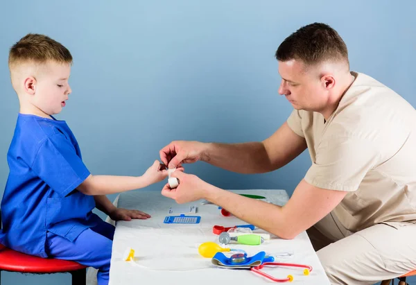 Medicinsk service. Man läkare sitta bord medicinska verktyg undersöker lilla pojke patienten. Barnläkare koncept. Hälsovård. Barnomsorg. Noggrann barnläkare kontrollera hälsan hos Kid. Läkarundersökning — Stockfoto