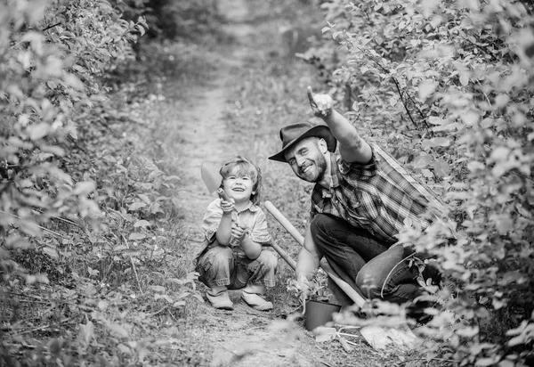 Glädjefull helg. far och son i cowboyhatt på Ranch. Eco Farm. liten pojke barn hjälpa pappa i jordbruket. Hoen, kruka och spade. Trädgårdsutrustning. Happy Earth Day. Släktträd nursering — Stockfoto