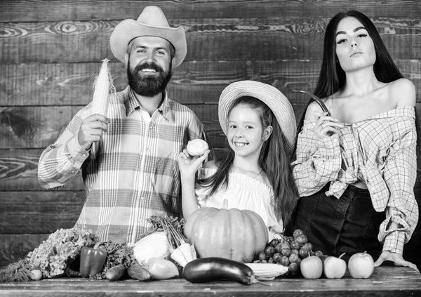 Padre de familia agricultor madre jardinero con hija cerca de la cosecha. Estilo de vida familiar del campo. Mercado agrícola con cosecha de otoño. Concepto de festival de granja familiar. Hombre barbudo granjero rústico con niño y esposa — Foto de Stock