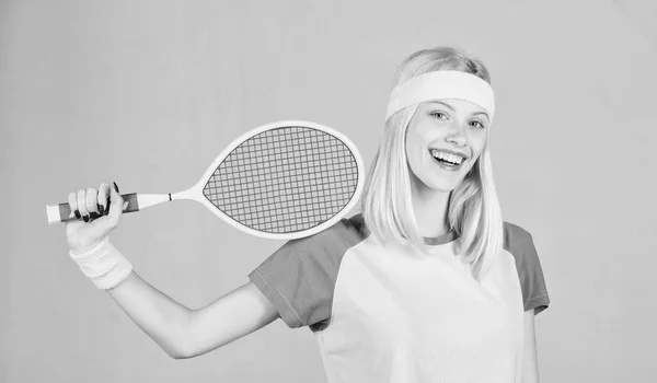 Sportler halten Tennisschläger in der Hand auf grauem Hintergrund. Tennissport und Unterhaltung. Tennisclubkonzept. Mädchen entzückende Blondine spielen Tennis. Sport zur Erhaltung der Gesundheit. Aktive Freizeit und Hobby — Stockfoto