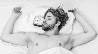 Neşeli genç adam sabah uyku sonra uyanıyor. Çıplak ayak altından cove bakmak bir adam. Sabah.