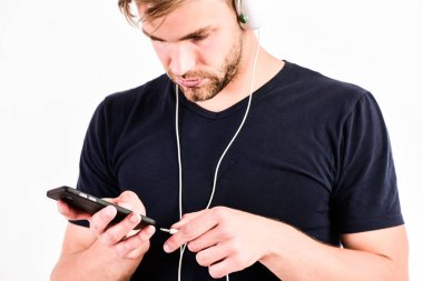 kablosuz mavi diş kulaklık kullanan adam. çalma listesini gevşetin. seksi kaslı adam çalma listesinden müzik dinlemek. adam kulaklıklar beyaz izole dinlenmek. traşsız adam favori şarkı ile dinlenmek