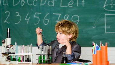 Çocuk biyoloji kimyası okuyor. Bilgi günü. Temel bilgi ilköğretim eğitimi. Mutlu çocukluk. Çocuk ders çalışmaktan zevk alır. Bilgi kavramı. Okul sınıfında mikroskop ve test tüplerine yakın çocuk