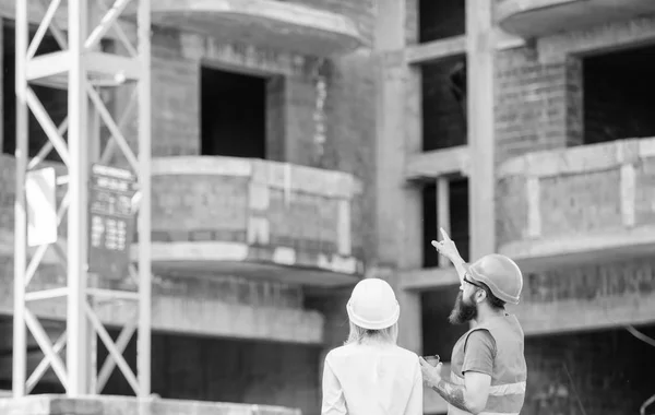 Vrouw ingenieur en bouwer communiceren op de bouwplaats. Relaties tussen bouw klanten en deelnemers bouwindustrie. Team communicatie bouwconcept. Bespreken van plan — Stockfoto