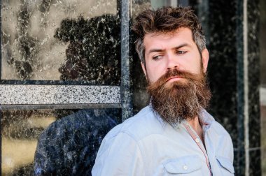 Erkeklik ve erkeklik. Yakışıklı adamın kendine güvenen duruşu. Uzun sakallı erkeksi bir görünüm. Berber konsepti. Sakal tımarı. Sakal bakımı. Adam çekici sakallı hipster açık havada poz