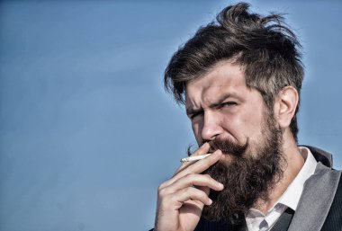 Bıyıklı acımasız beyaz hippi. Olgun hippi sakallı. Gelecekteki başarısı. Erkek resmi moda. Sakallı adam sigara içiyorum. duman. İş adamı gökyüzüne karşı. kopya alanı