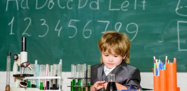 küçük çocuk kimya çalışma. küçük çocuk okul dersinde mikroskop kullanarak. Sonuç. Tıbbi konsept. Küçük dahi çocuk. araştırma için sıvı ile test tüpleri. gelecek için öğrenmek. Çok çalışmak için ilham