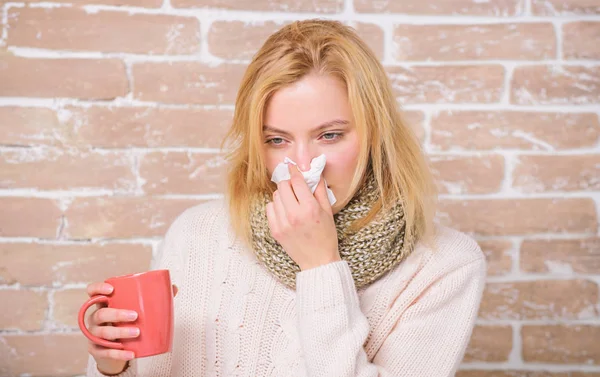 Girl hold tea mug and tissue. Runny nose and other symptoms of cold. Drinking plenty fluid important for ensuring speedy recovery from cold. Cold and flu remedies. Drink more liquid get rid of cold