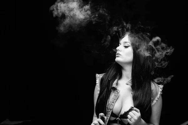 Girl vaping. Hookah bar. Electronic cigarette. Fashion girl vaping. Relaxing with hookah. White cloud of smoke. Vaping is sexy. Nicotine addiction. Attractive busty brunette smoking vaping device