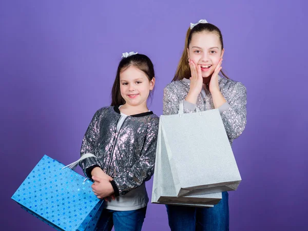 Filles sœurs amis avec sacs à provisions fond violet. Achats et achats. Vendredi noir. Vente et rabais. Journée shopping. Des paquets d'enfants. Mode pour enfants. Découvrez quelque chose de nouveau — Photo