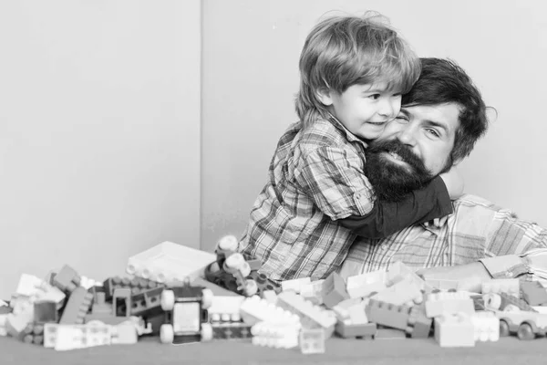 Importancia de jugar juntos. Concepto de cuidado infantil. Familia feliz. Desarrollo y crianza infantil. Padre e hijo diviértanse. El hipster barbudo y el chico juegan juntos. Papá y su hijo construyen bloques de plástico —  Fotos de Stock