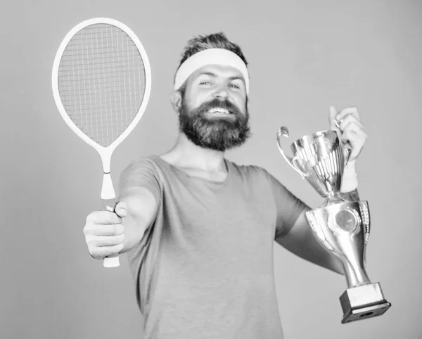 Gana un partido de tenis. Ningún jugador puede pisar la cancha contra mí y sentirse seguro. Hombre barbudo hipster llevar traje deportivo. Jugador de tenis gana el campeonato. Atleta hipster mantenga raqueta de tenis y copa de oro — Foto de Stock