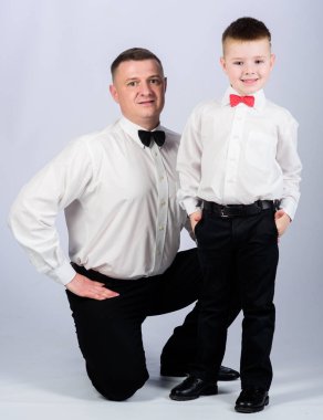 Resmi bir olay. Küçük oğul soylu bir adam babaları örnek takip. Centilmen yetiştirilme tarzı. Baba ve oğul resmi kıyafet kıyafeti. Büyüyün beyefendi. Papyonlu baba ve çocuk. Centilmen yetiştirme