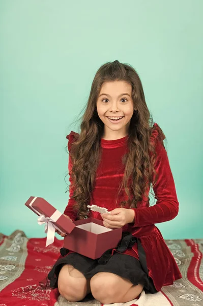 Opening xmas present. Happy little smiling girl open Christmas gift box. Cute little child girl with Christmas present. Kid enjoy Christmas holiday. Merry Christmas and Happy Holidays