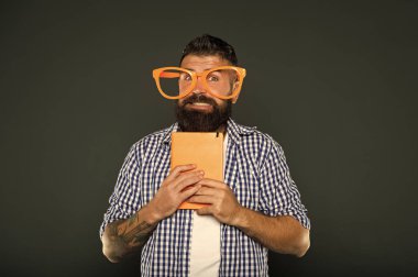 Tam bir. Ders notları ile üniversite erkek öğrenci. Ders kitabıyla parti gözlüklü sakallı adam. Kitap süslü gözlük takıyor. Çalışma nerd tutma kitap