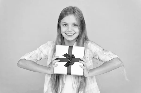 Na druhý svátek vánoční. Malá holčička po nakupování na dárek. Malý shopaholic dárek zabalený v rozevíracím seznamu. Malé dítě drží krabičky převázaná stuhou luk. Roztomilý shopper užít nakupování trochu — Stock fotografie