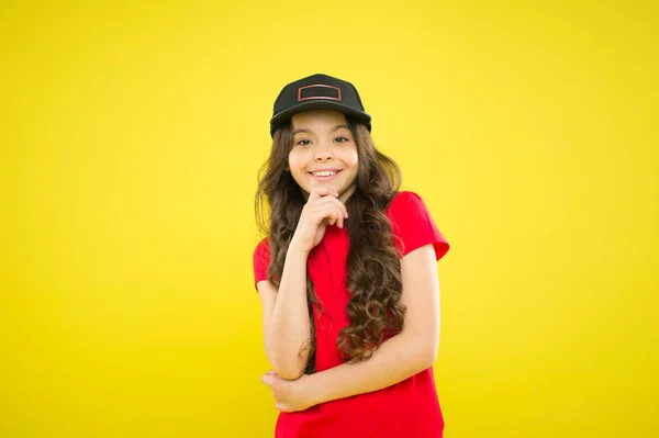 Deve ter tendências acessórias de estilo de rua. Moda moderna. Moda infantil. Menina bonito criança usar boné ou chapéu snapback. Menina usando boné de beisebol. Confortável e fixe. Menina longo cabelo encaracolado desgaste cap — Fotografia de Stock