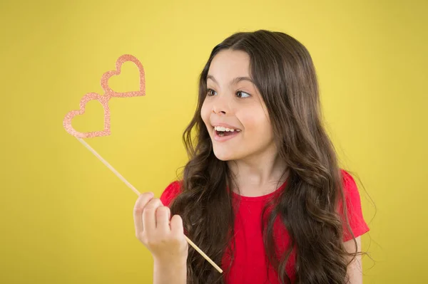 Party shop. Valentines day concept. Happy little child glasses props. Funny small girl holding glasses photo booth props on stick. Cute kid with fancy party props. Party decorations supplier — Stock Photo, Image