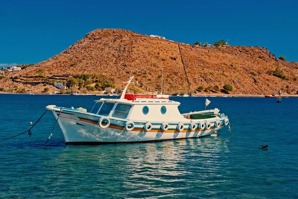 Nyaralás és a tengeri utazás. Csónak, kék tenger Patmos, Görögország. Kis hajó a tengerparton, a hegy a napfényes ég. Hajó és a vízi közlekedésben. Mehetnék és a felfedezés — Stock Fotó