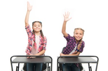 Çalışma sürecinin keyfini çıkarın. Küçük kızlar okul arkadaşları birlikte çalışır. Cevap vermek için ellerinizi kaldırın. Öğrenciler sınıf arkadaşları masa başında. Okula geri dön. Özel okul konsepti. İlkokul eğitimi