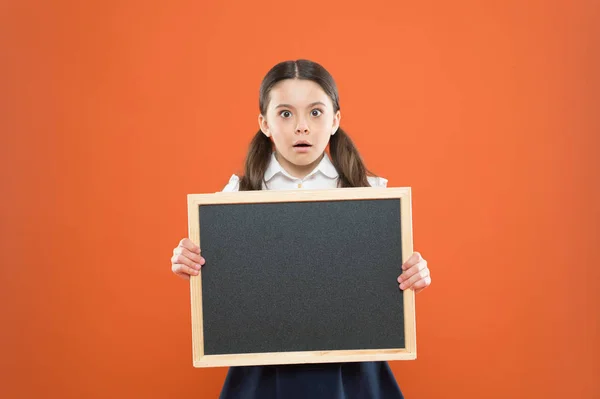 Ihren Text finden Sie hier. Informationen. Hausaufgaben schreiben. zurück zur Schule. Lehrertag. 1. September. kleines Mädchen demonstrieren Ansage. überraschte kleine Schulmädchen mit Kreidetafel. Tafel für Kopierraum — Stockfoto