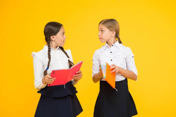 Étudier la langue. Les enfants mignons étudient avec un manuel. Pratiquer et améliorer les compétences en lecture pour les études scolaires. Retour à l'école. Les filles tiennent le livre. Les écolières étudient ensemble sur fond jaune — Photo