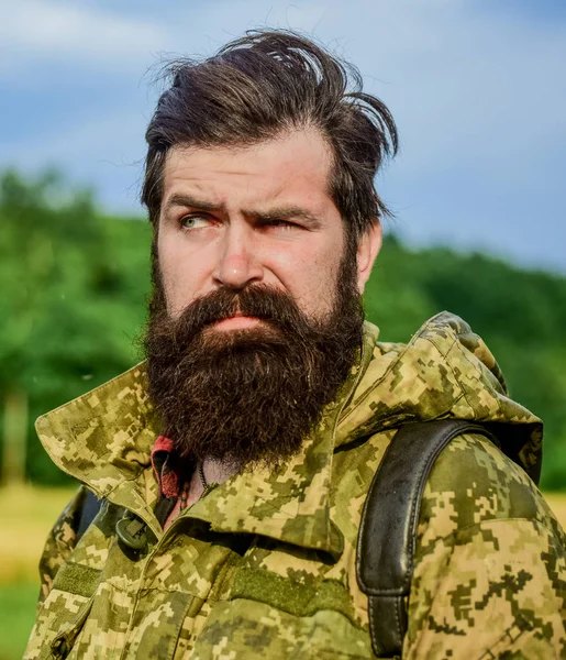 windy weather. Hunter man. Hunting season. soldier in military uniform. brutal male poacher. male beard care. bearded man hiking with backpack. mature hipster with beard in military jacket