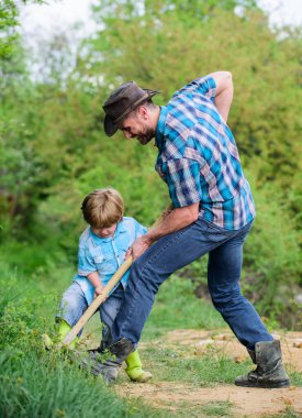 mutlu dünya günü. Kürekli mağara kaz. yeni bir hayat. toprak ve gübre. zengin doğal toprak. Eko çiftlik. Çiftliği. küçük çocuk çocuk tarım baba yardım. baba ve oğul aile ağacı dikiyor. Toprağın bakımı