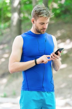 İyi sonuçlar. Fitness bileziğindeki kaslı adam. Telefonda spor uygulaması kullan. Dijital spor. Formda kalmak için akıllı bir saat. Spor giyim sektöründe sporcu. Açık hava antrenmanı. Fitness uygulaması. Ui ux kavramı. gadget sporu