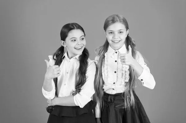 Pollici in su per la scuola chic. Bambini di scuola con moda. Bambine che indossano uniformi alla moda. Ragazze eleganti in trecce vestite per la scuola. Belle scolarette. Ritorno a scuola stile moda — Foto Stock