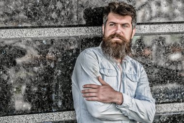 Uzun sakallı erkeksi bir görünüm. Berber konsepti. Sakal tımarı. Sakal bakımı. Adam çekici sakallı hipster açık havada poz. Erkeklik ve erkeklik. Yakışıklı adamın kendine güvenen duruşu