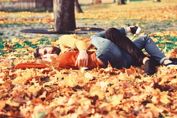 Casal apaixonado encontra-se em folhas caídas no parque — Fotografia de Stock