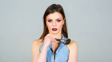 Kusurları gizliyor. İyi görünmek ve kendinden emin hissetmek. Makyaj koyu dudaklar. Makyaj fırçası uygulayan çekici kadın. Profesyonel makyaj malzemeleri. Makyaj sanatçısı kavramı. Kız toz göz farları uygulamak