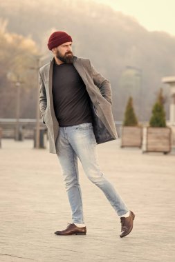 Yürüyüş yenileniyor. Hippi kıyafet ve şapka aksesuar. Şık casual kıyafet bahar mevsimi. Erkek giyim ve erkek moda kavramı. Adam hipster şık moda palto ve şapka sakallı. Rahat kıyafet