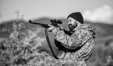 Avcılık ve yakalama mevsimleri. Avcılık erkeksi hobi. Adam acımasız gamekeeper doğa arka plan. Hunter tüfeği tutuyor. Sakallı avcı boş zamanlarını avlayarak geçirir. Odak ve deneyimli avcı konsantrasyonu