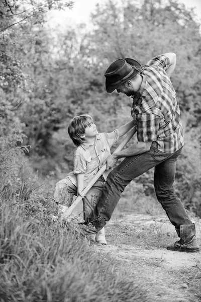 父と息子は家系図を植える。豊かな自然の土壌。エコファーム牧場。小さな男の子の子供は、農業で父親を助けます。新しい生活。土壌と肥料。幸せな地球の日。シャベルで溝を掘る。小さな植物 — ストック写真
