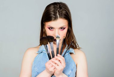Farklı fırçalar. Profesyonel makyaj malzemeleri. Cilt bakımı. Makyaj kozmetik kavramı. Cilt tonu kapatıcı. Kozmetik dükkanı. Kız göz farı uygular. Makyaj fırçası uygulayan kadın. Kadınlığı vurgulayın