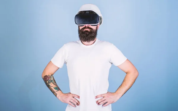 Man with beard in VR glasses serious and confident, light blue background. Architect or engineer with virtual reality glasses. Guy in helmet works as engineer in virtual reality. 3D design concept