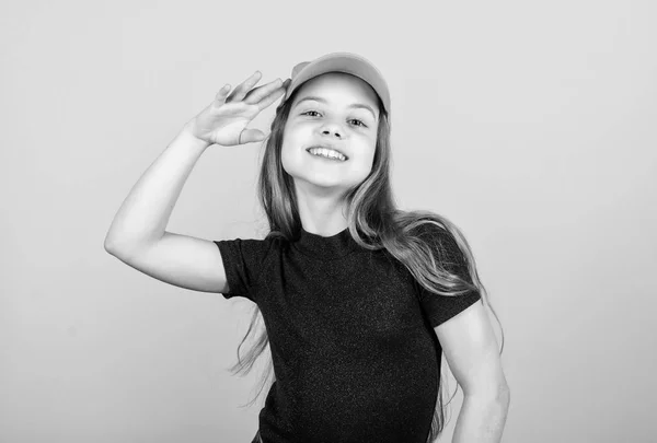 Um acessório elegante. Moda infantil. Sentindo-se confiante com este boné. Menina bonito criança usar boné ou snapback chapéu bege fundo. Menina vestindo boné de beisebol brilhante. Chapéu ou boné. Moda moderna — Fotografia de Stock