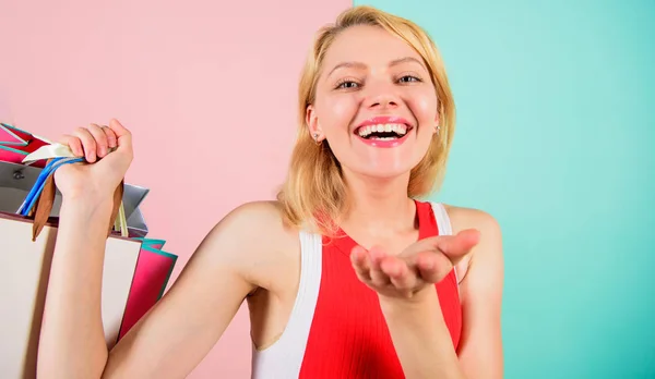 Consejos para comprar ventas con éxito. Mujer vestido rojo sostienen manojo bolsas de compras fondo rosa azul. Compra todo lo que quieras. Chica satisfecha con las compras. Chica disfrutar de compras o acaba de recibir regalos de cumpleaños —  Fotos de Stock