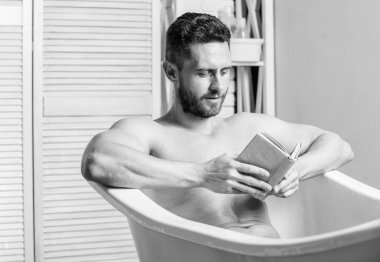 Sinir sistemi banyo yarar. Rahatla konsepti. Adam kas gövde küvet dinlenmek ve kitap okuyun. Sıcak banyoda dinlenirken rahat adam kitap okuyor. Evde rahatlayın. Tam bir rahatlama. Kişisel hijyen