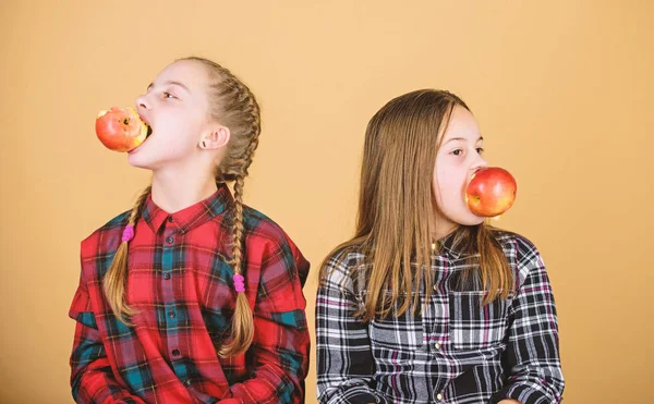 Фрукты, фрукты и другие фрукты. Девочки едят свежие фрукты. Маленькие девочки держат яблоки во рту. Милые дети наслаждаются здоровой закуской. Очаровательные сестры, имеющие натуральные органические закуски — стоковое фото