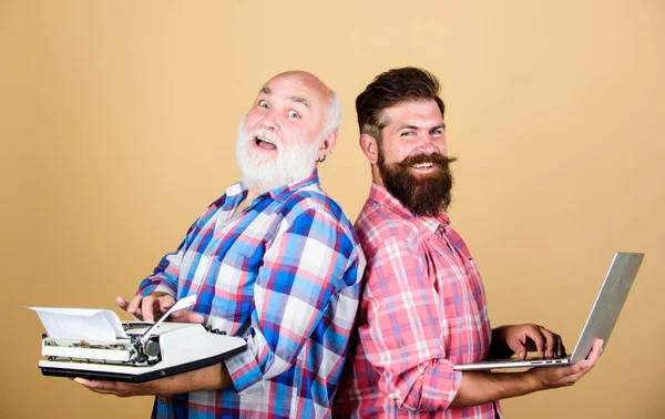 Business partners. technology battle. Modern life. youth vs old age. business approach. father and son. two bearded men. Vintage typewriter. retro typewriter vs laptop. New technology generation — Stock Photo, Image
