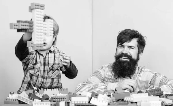 Father son create constructions. Father and boy play together. Dad and kid build plastic blocks. Father leader showing boy how grow into successful man. Child care and upbringing. Father son game