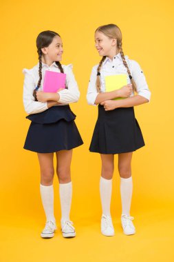 Küçük gruplar halinde eğitim. Notlar için okul günlükleri olan çocuklar. Okula geri dön. Yazmak için çalışma kitapları olan küçük kızlar. Ders kitapları tutan sevimli kız öğrenciler. Okul çocukları kitap okumayı öğrenir