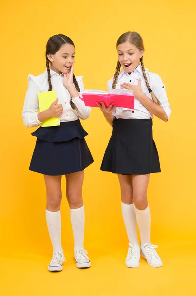 Souvenirs d'enfance. jolies filles étudient avec un bloc-notes. travailler ensemble. leçon de littérature. retour à l'école. camarades de classe à la librairie ou à la bibliothèque. petites filles enfants avec livre. lecture et écriture — Photo